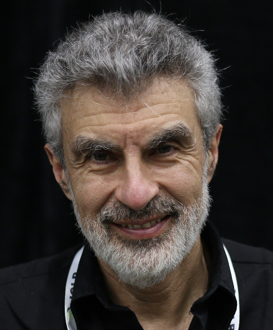 Kır saçlı ve sakallı, gülümseyen bir adam