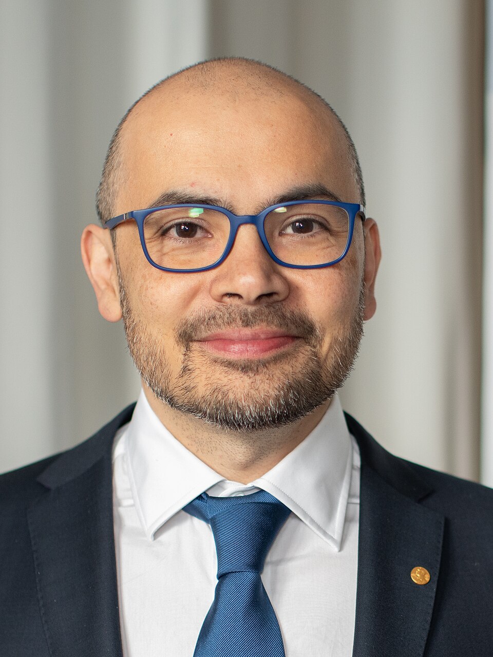 Gözlüklü, saçsız, takım elbiseli bir adam