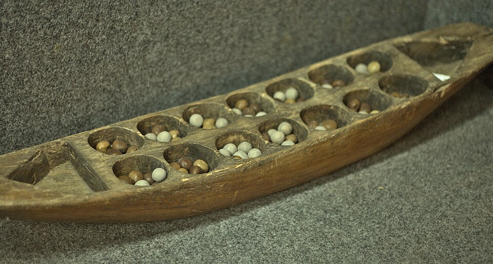 Çukurlu ahşap mancala tahtası ve taşlar